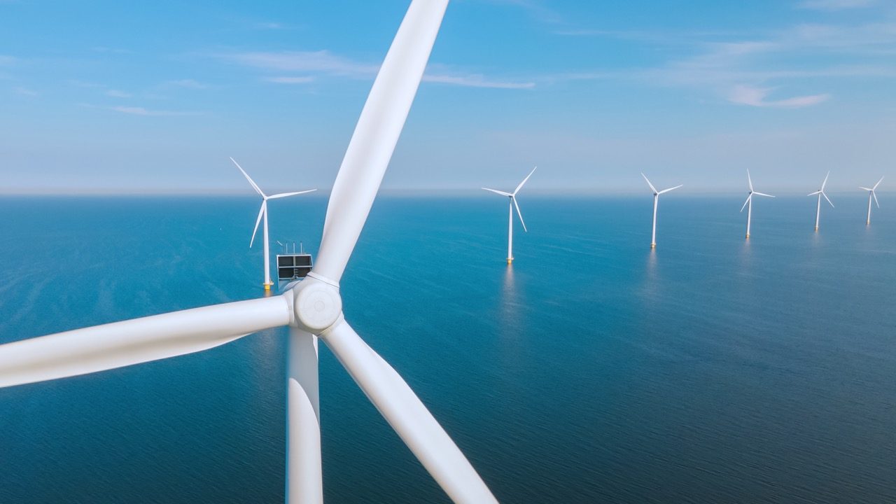 Windmill turbines at sea generate green energy in the Netherlands. Drone view at windmill park